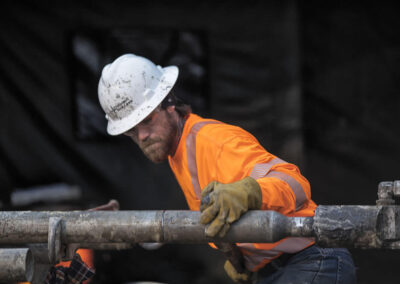 Driller assistant attaching HQ core pipe.