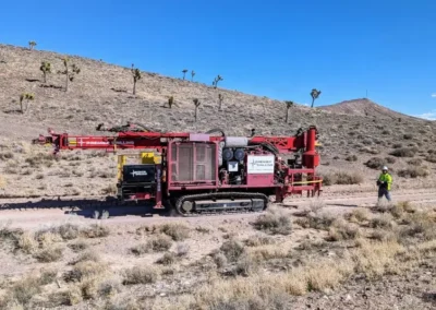 Remote-controlled Schramm 450 GT reverse circulation exploration rig tramming across desert terrain.